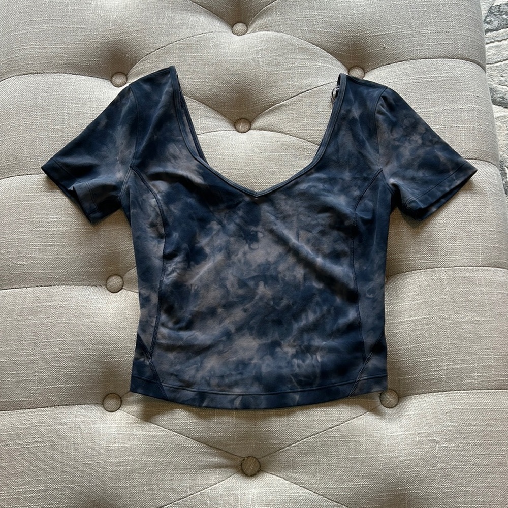 Never worn, blue and mauve watercolor short-sleeve Lululemon shirt. Size 4.